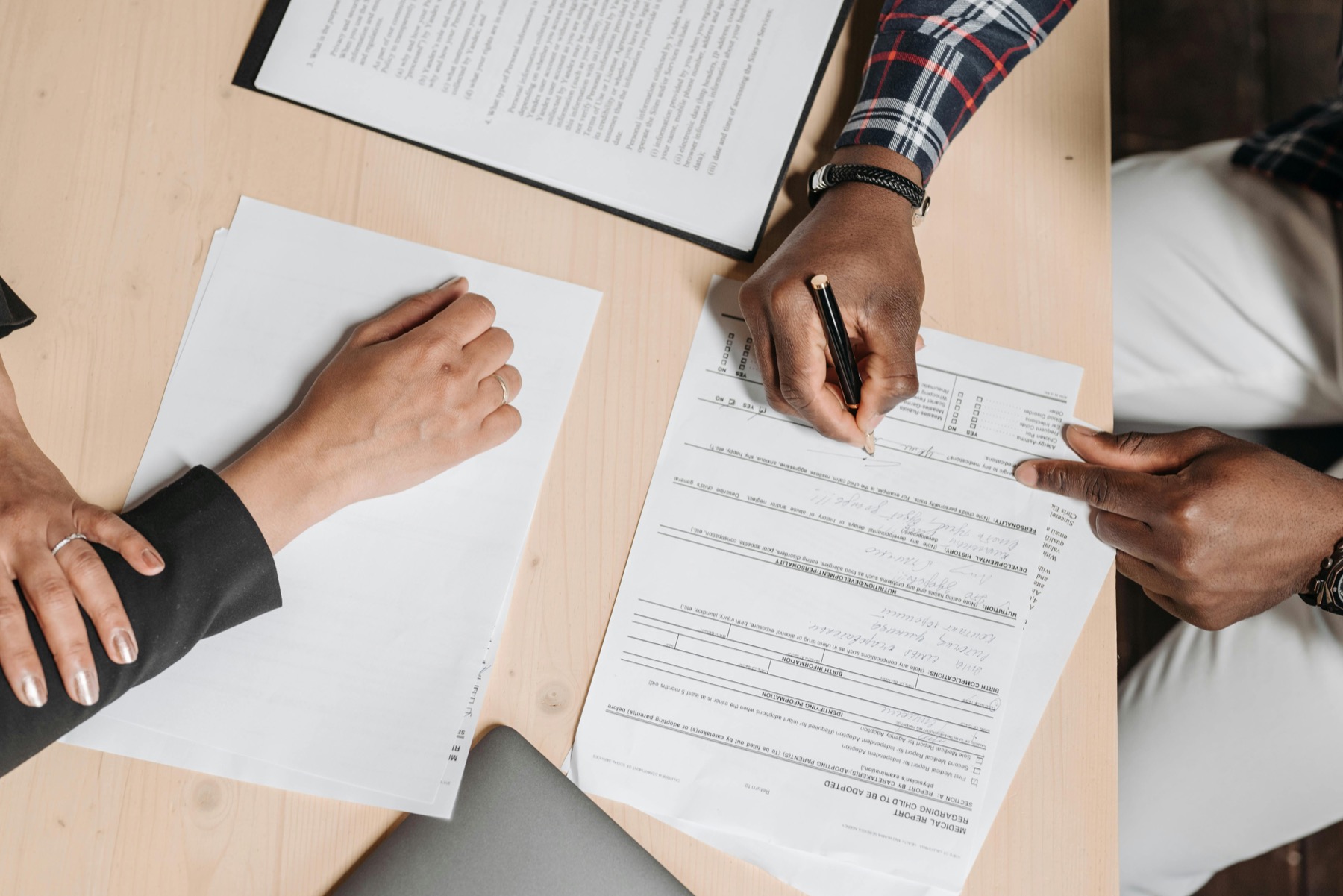 Documents administratifs en cours de signature sur un bureau