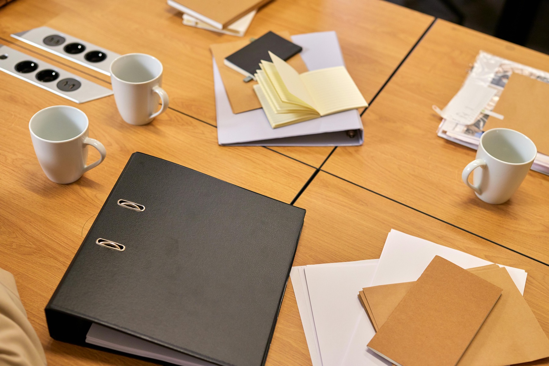 Documents, classeurs et carnets organisés sur une table de travail